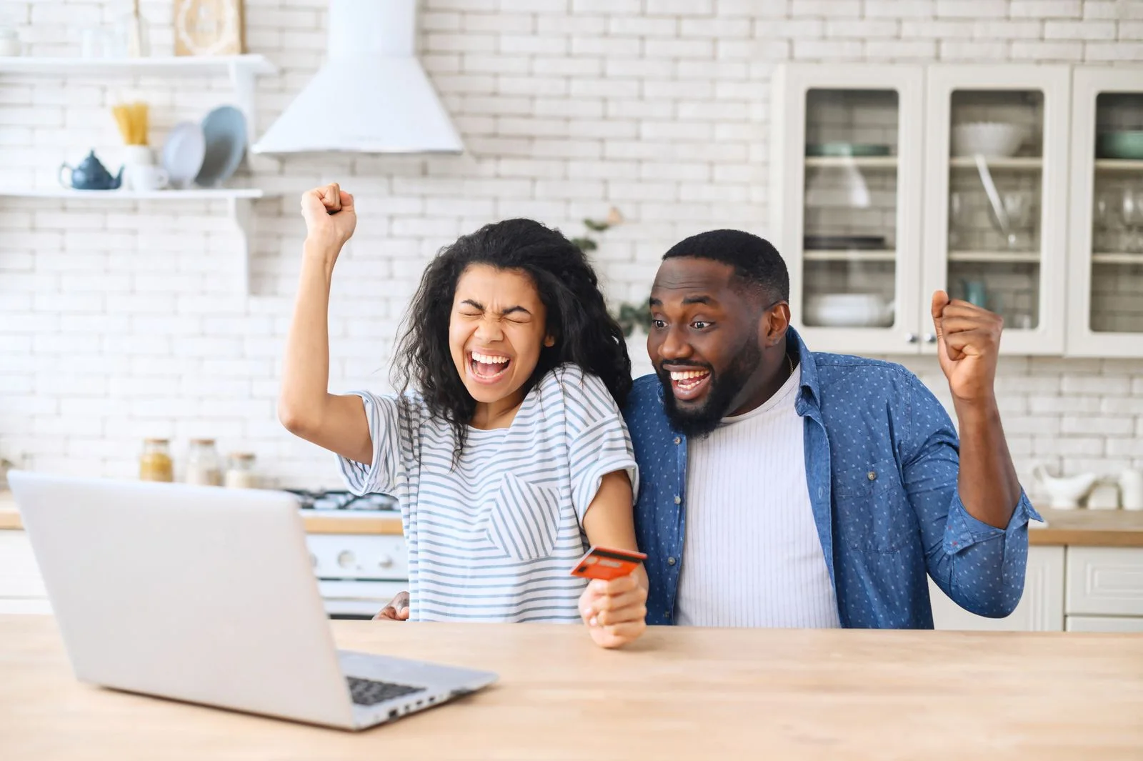Excited clients celebrating together in front of a laptop.